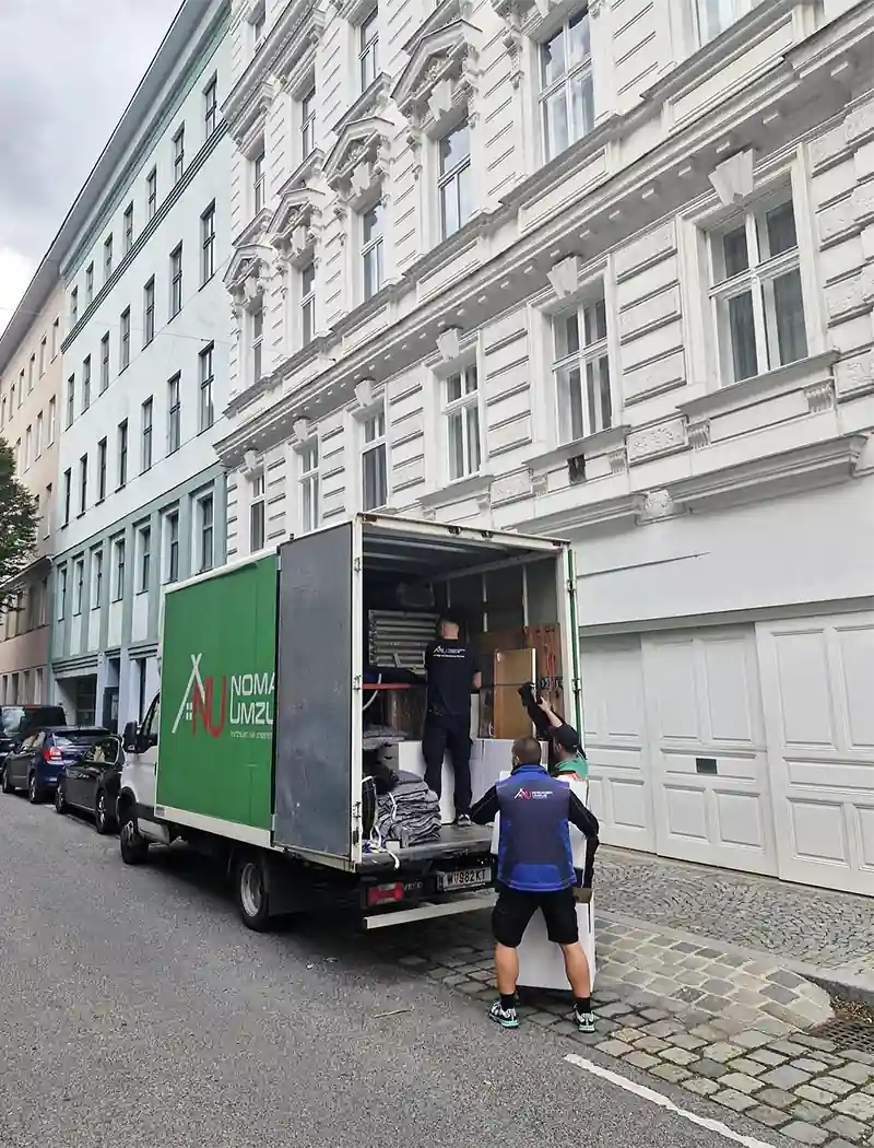 Nomaden Umzug Wien – Umzugsarbeiter beim Be- und Entladen vor Wiener Altbau
